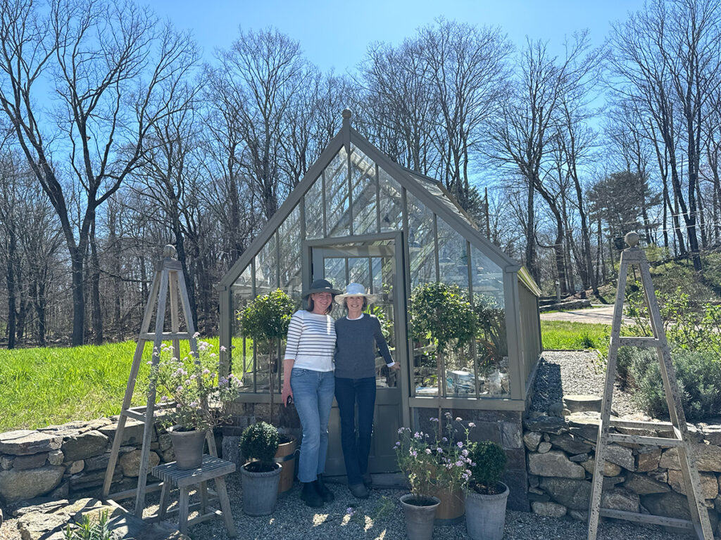 Andrea Spunberg and Leslie Needham, of Leslie Needham Design, stand outside of Leslie's greenhouse on a beautiful spring day.