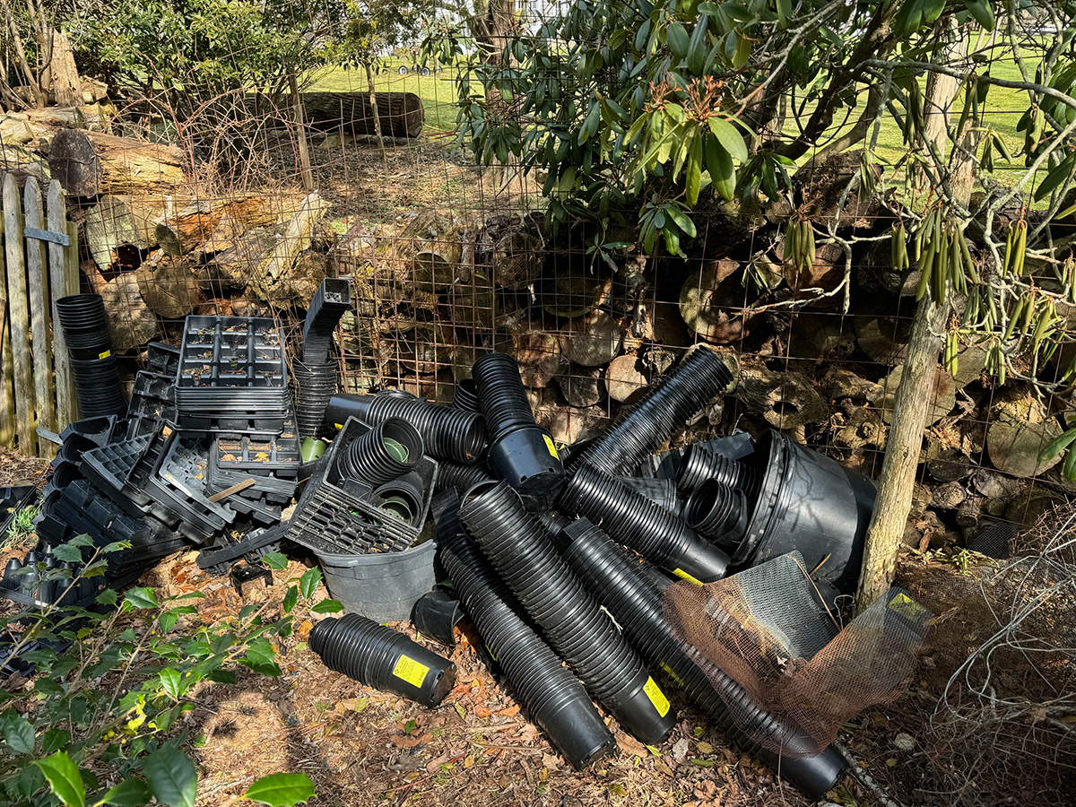 Heap of black plastic plant pots.